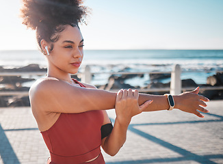 Image showing Stretching, fitness and woman with music for running, exercise and cardio in California. Ready, warm up and runner girl thinking of a workout start with audio for motivation while training by the sea