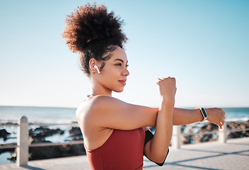 Image showing Stretching, start and woman with music for running, exercise and cardio in California. Ready, warm up and runner girl thinking of a workout with audio for motivation while training by the sea