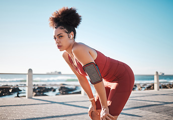 Image showing Fitness, music and exhausted with a black woman runner on the promenade for cardio or endurance training. Exercise, running and earphones with a sports person feeling tired during her workout