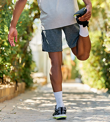 Image showing Stretching, fitness and legs of a man in nature for running, exercise and training in Morocco. Marathon, workout and back of an athlete with a warm up to start cardio, race or sports in a park