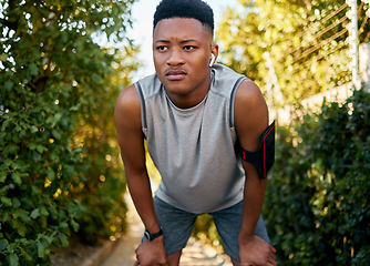 Image showing Fitness, running and tired with a sports black man outdoor during summer taking a break from a workout. Exercise, health and exhausted with a male runner or athlete resting while training outside