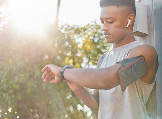 Image showing Fitness, black man and watch checking time or performance for running exercise, workout or training in nature. African American male runner looking at wristwatch for tracking or monitoring cardio