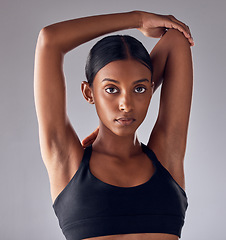 Image showing Exercise, face portrait and woman stretching for cardio fitness running, marathon training or body healthcare goals. Performance workout, studio health or athlete warm up isolated on grey background