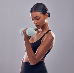 Image showing Black woman, dumbbells training and studio for muscle development, wellness and self care with focus. Gen z bodybuilder girl, exercise and strong healthy body with gym equipment by gray background