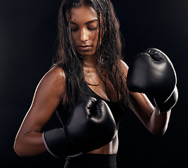 Image showing Boxing, gloves and sweating with a sports woman getting ready in studio on a black background for fitness. Exercise, health and sweat with a female athlete or boxer training during a combat workout