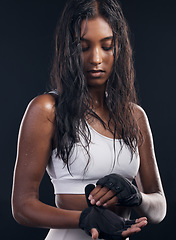 Image showing Boxing, gloves and sweat with a sports woman getting ready in studio on a black background for fitness. Exercise, health and training with a female athlete or boxer sweating during a combat workout