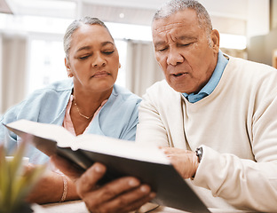 Image showing Bible, praying or old couple reading a book together in a Christian home in retirement with hope or faith. Jesus, religion or belief with a senior man and woman in prayer to god for spiritual bonding