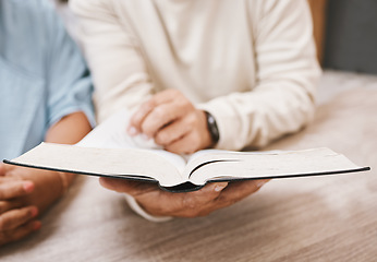 Image showing Hands, bible and prayer with a senior couple reading a book together in their home during retirement. Jesus, faith or belief with a man and woman praying to god in their house for spiritual bonding