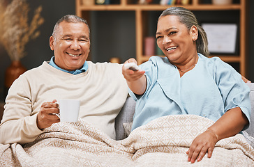 Image showing Coffee, relax and old couple watching tv with blanket on sofa in home living room laughing at comic film. Retirement portrait, valentines love and happy elderly man and woman streaming on television.