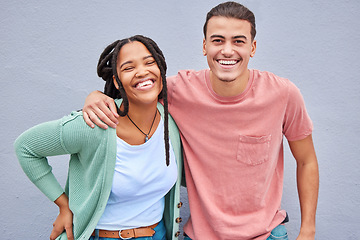 Image showing Love, romance and portrait of a happy couple by a wall in the city while on a vacation or weekend trip. Happiness, smile and interracial man and woman embracing while walking in town on a holiday.