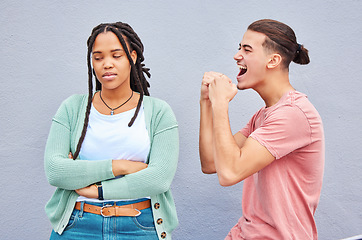 Image showing Winner, competition and celebration with a man cheering after winning a bet against his loser girlfriend on gray background. Success, wow or victory with a boyfriend celebrating a win against a woman