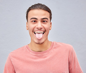 Image showing Man, tongue or funny face on isolated background in silly, goofy or comedy on grey mockup, wall or mock up backdrop. Comic, emoji or happy student in fashion clothes, style trend or facial expression