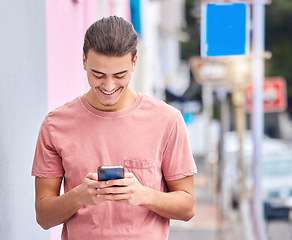 Image showing Man, cellphone and typing in city for social media, technology and iot networking. Happy young guy walking in urban street with smartphone, connection and reading notification of online internet post