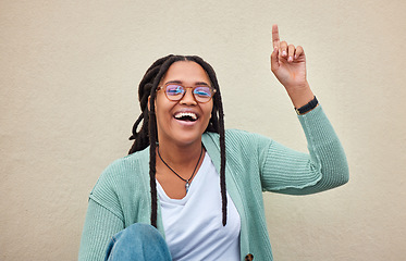 Image showing Up sign, portrait and black woman pointing with mockup in studio for advertising, space and wall background. Face, direction and girl happy, smile and excited for product placement on copy space