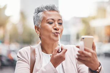 Image showing Woman, phone and lipstick in city for makeup, happy or cosmetics for financial service career. Accountant, cosmetic and face beauty by blurred background in metro, summer and smartphone for aesthetic