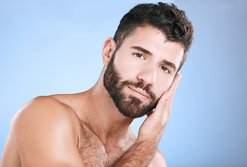 Image showing Skincare, cosmetic and portrait of a man feeling face isolated on a blue background. Beauty, clean and model touching facial beard, grooming and cleaning for dermatology treatment on studio backdrop