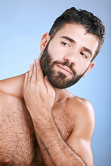 Image showing Idea, skin and grooming with a man model in studio on a blue background for natural wellness or beauty. Face, beard and skincare with a handsome young male thinking about cosmetics or treatment