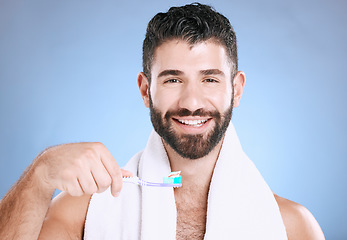 Image showing Toothbrush, portrait and man cleaning in studio for dental wellness, healthy smile and mouth. Happy male model brushing teeth, face and care of fresh breath, oral gums or dentistry on blue background