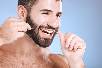 Image showing Dental, product or floss with a man in studio on a blue background with teeth hygiene for healthy gums. Dentist, healthcare and mouth with a young male oral cleaning to remove plague or gingivitis