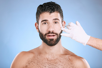 Image showing Needle, man and portrait for skincare, collagen and beauty process in studio. Cosmetics, surprise face and injection for plastic surgery of botox, facial change and aesthetic prp on blue background