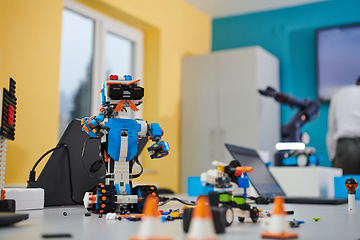 Image showing A student testing his new invention of a robotic arm in the laboratory, showcasing the culmination of his research and technological prowess.