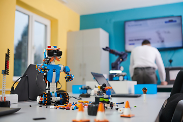 Image showing A student testing his new invention of a robotic arm in the laboratory, showcasing the culmination of his research and technological prowess.