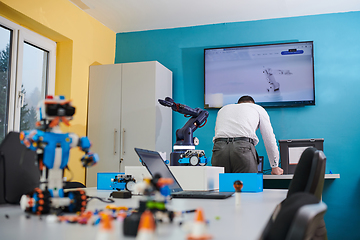 Image showing A student testing his new invention of a robotic arm in the laboratory, showcasing the culmination of his research and technological prowess.