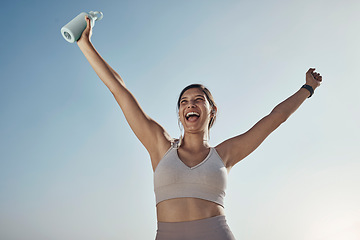 Image showing Fitness success, blue sky and woman arms in air with water bottle outdoor. Excited, happy smile and athlete with sports feeling freedom from motivation and happiness with exercise target goal