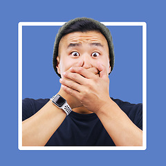 Image showing Portrait, man and hands over mouth for wow, shocked and news in studio for advertising on blue background. Omg, face or emoji by asian guy shock for secret, drama or secret on mockup space isolated