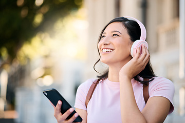 Image showing Headphones, happy and music by woman in city for travel, mindset and smile on building background. Radio, podcast and travelling girl student with app, online audio or subscription service outside