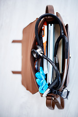 Image showing Top view, doctor bag and clinic with stethoscope, books and glasses on desk for job in medical industry. Doctors, nurse or medic tools in leather case for healthcare, wellness and help at hospital