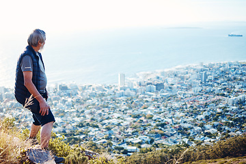 Image showing Hiking, explore and senior man with city view for on an adventure, workout and fitness in Cape Town. Training, exercise and elderly person trekking on a mountain for health and wellness