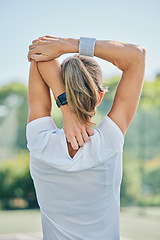 Image showing Tennis, back and stretching arm with a sports woman on a court for a warm up before a competitive game. Sport, fitness or training with a female athlete getting ready for a practice match from behind