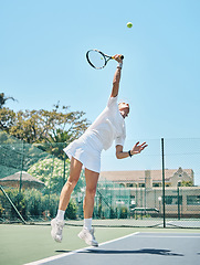 Image showing Tennis serve, sports and woman jump on outdoor court, fitness motivation and competition with athlete training for game. Workout, healthy and player on turf, active with sport and exercise action