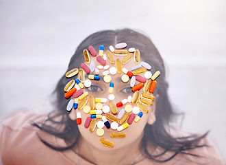 Image showing Addiction, pills and medicine on woman face as drug abuse from overhead view looking serious and covered by medication. Tablets, issue and antibiotics problem by mental health patient or female