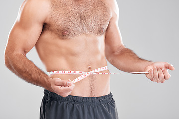 Image showing Health, diet and man with measuring tape on stomach, healthy exercise weight loss and body care. Sports, nutrition and fitness, tracking weightloss and six pack progress isolated on grey background.