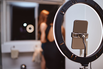 Image showing ring light, phone and woman influencer equipment with friends live streaming getting ready. Night, creative gen z content and internet production tech with blurred background and mockup in a home