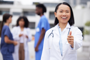 Image showing Thumbs up, happy and portrait of a doctor outdoor of the hospital with a leadership mindset. Happy, smile and Asian female healthcare worker with a success or agreement gesture in a medical clinic.