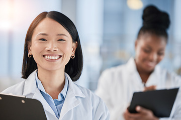 Image showing Asian doctor woman, checklist and portrait with smile, planning or happy at clinic with african expert. Medic, teamwork and clipboard for schedule, analysis or results in hospital for healthcare goal