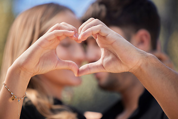 Image showing Happy, heart shape and couple hugging in nature while on romantic date for valentines day or anniversary. Intimacy, affection and young man and woman embracing with love hand sign or gesture together
