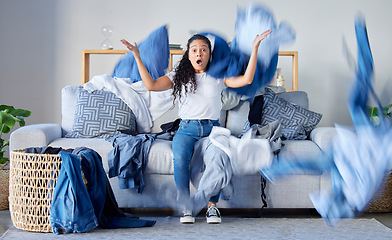 Image showing Laundry, frustrated and upset woman in the living room throwing the clothes with anger at her home. Crazy, busy and angry female maid, housewife or cleaner with blur motion of dirty washing at house.