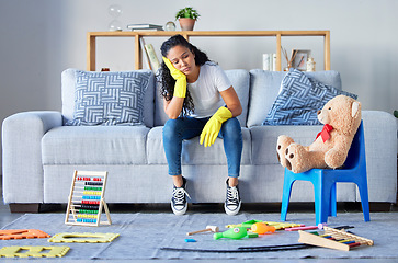 Image showing Tired, cleaning and black woman in living room with chaos and stress from toys at home. Cleaner, stress and burnout from housekeeping work on a lounge couch ready for sleeping from anxiety and mess