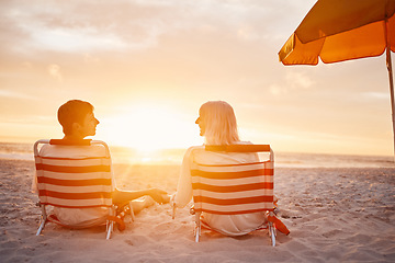 Image showing Beach, back and couple holding hands during the sunset for support during a date on valentines day. Travel, relax and man and woman with affection, trust and conversation sitting by the ocean