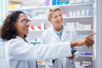 Image showing Pharmacy women, shelf and pointing together with smile, stock and product for medical wellness in store. Pharmacist training, management and teamwork for medicine, service and healthcare in shop