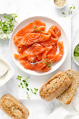 Image showing Salted salmon sliced on plate on a white background, top down view