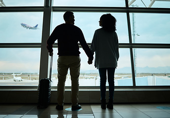 Image showing Silhouette, travel and holding hands with couple in airport for departure, flight and vacation break. Shadow, holiday and tourism with man and woman by window for journey, international and boarding