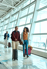 Image showing Travel, happy and smile with interracial couple in airport for vacation, tourism and departure. International trip, luggage and holiday with man and black woman walking for flight, journey or airline