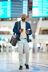 Image showing Black man with phone, airport and flight schedule, walking in terminal, holding ticket and passport for business trip. Smile, travel and happy businessman checking international destination online.