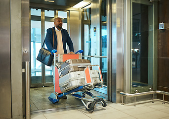 Image showing Black man, travel for business and luggage with airport and conference, exit elevator with suitcase and corporate trip. Businessman, finance convention or seminar and travelling, ready for flight