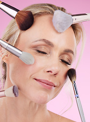 Image showing Makeup, glam and face of a woman with brushes isolated on a pink background in a studio. Beauty, foundation and mature model with cosmetics from a beautician for a glamour look on a backdrop